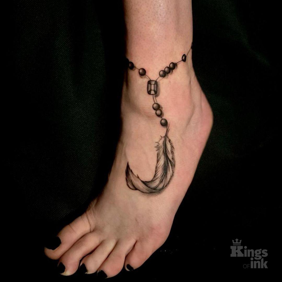 Bransoletka z koralikami zakończona piórkiem.