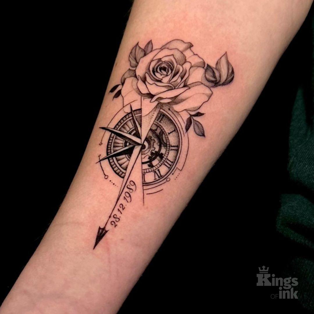 Kompas z różą na górze przecięty strzałką skierowaną w dół, na której znajduje się data.