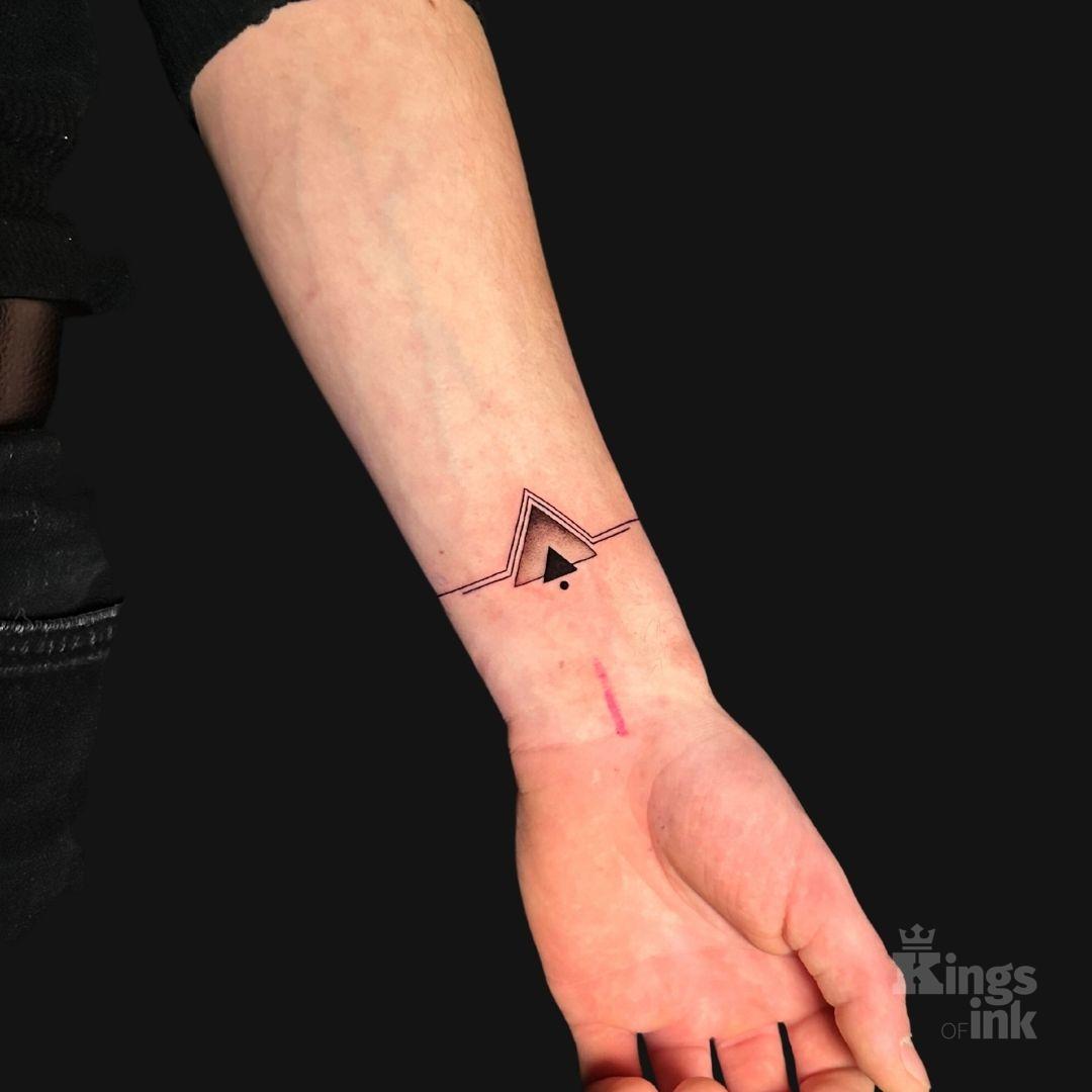 Czarny mniejszy trójkąt i większy z różnym gradientem, wokół którego układają się dwie linie w jego kształcie.