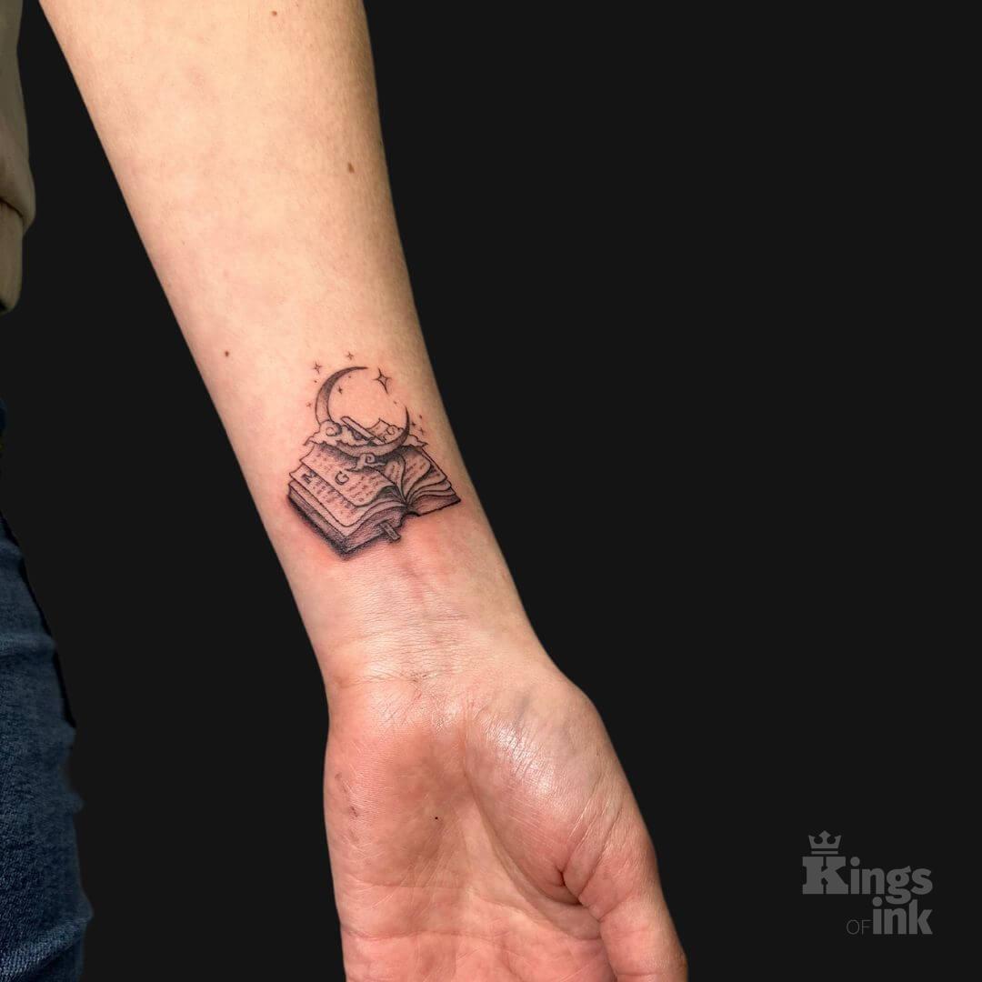 Otwarta książka, na której znajduje się księżyc z gwiazdami.