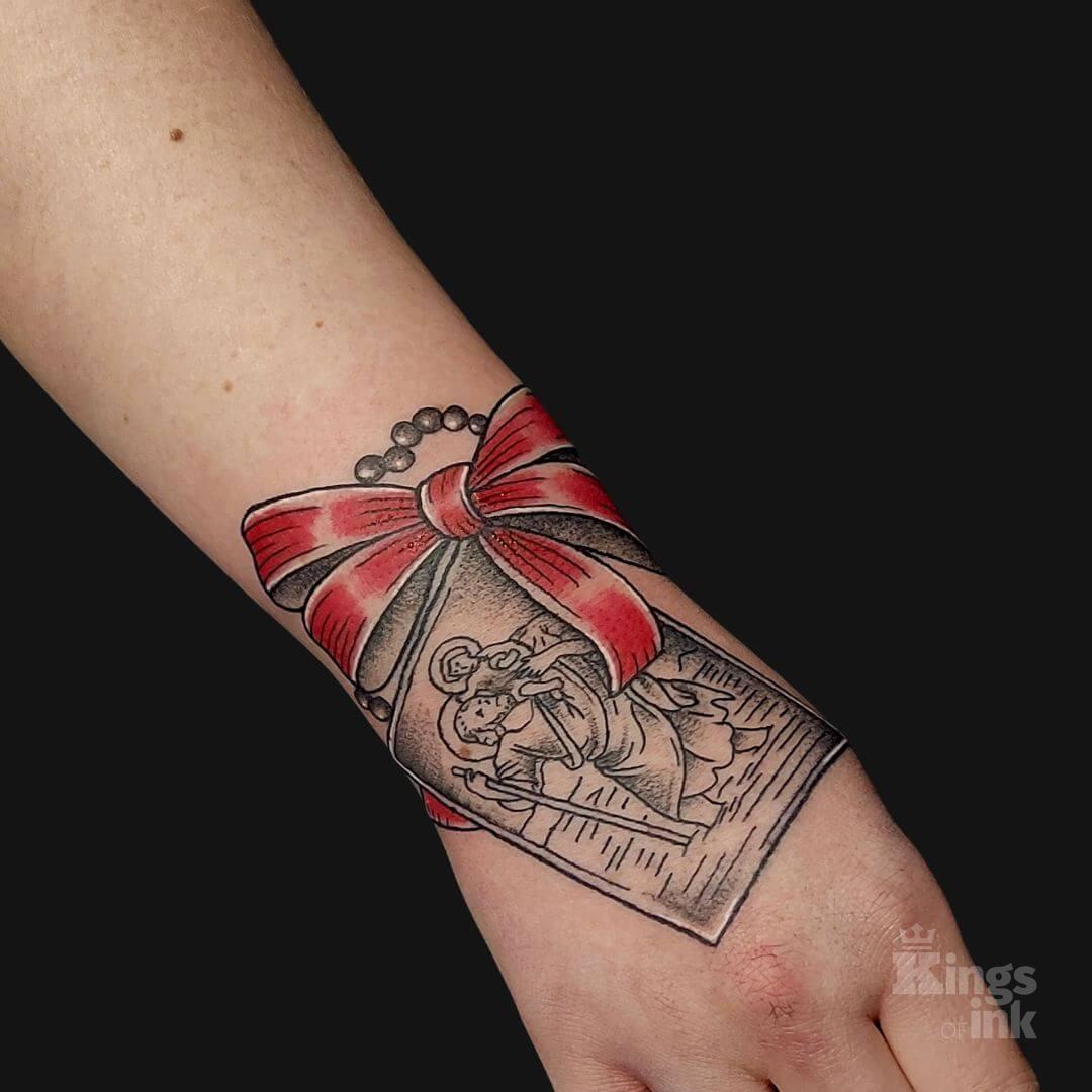 Obrazek z czerwoną kokardą oraz różańcem.