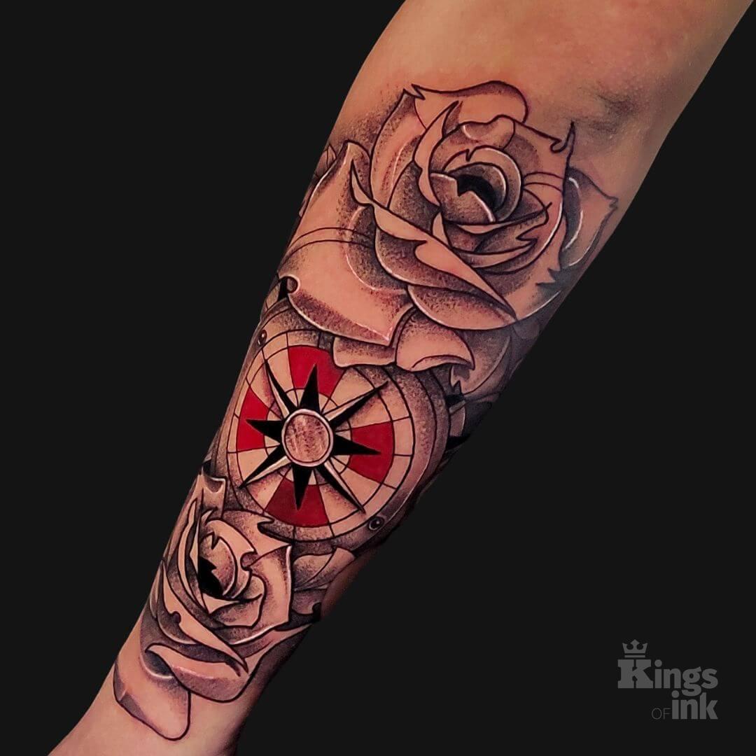 Kompas, który otaczają róże.